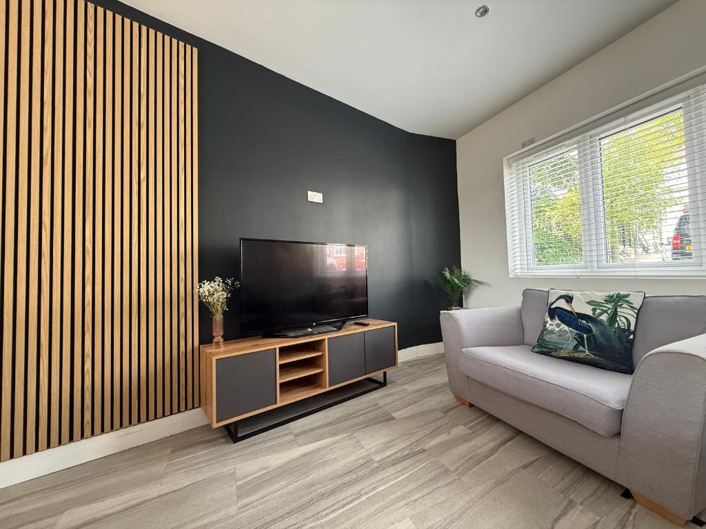 ein Wohnzimmer mit Couch und Flachbildfernseher in der Unterkunft Stylish 3-Bed Executive Home Chislehurst, BR7 in Chislehurst