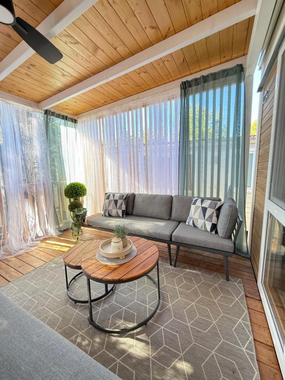 een woonkamer met een bank en een tafel bij Mobile Home LOREN in Biograd na Moru
