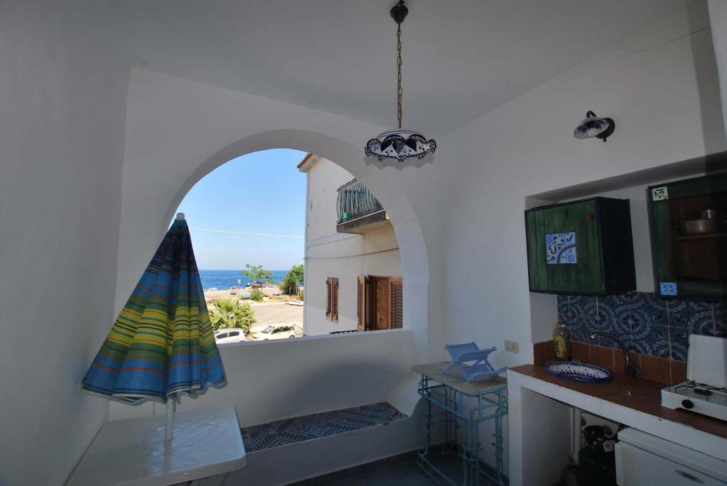 a kitchen with a view of the ocean from a window at Cannella studio flat Canneto Lipari in Canneto - Lipari