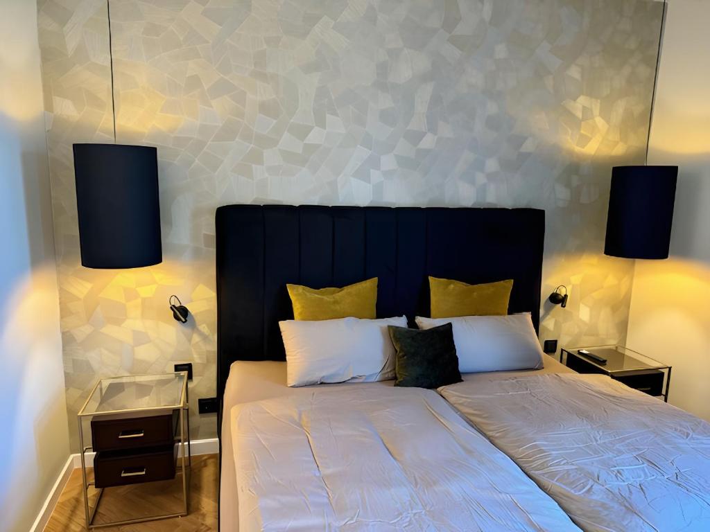 a bedroom with a large bed with two lamps at Zeitloser Luxus am Wasserschloss in Neukirchen