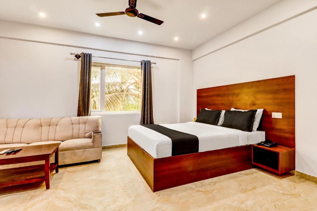 a bedroom with a bed and a couch at Collection O Airport Inn in Bengaluru