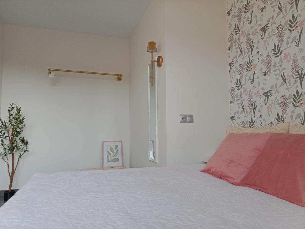 a bedroom with a white bed with a red blanket at Abril 56 Villa&Suites in Oreña