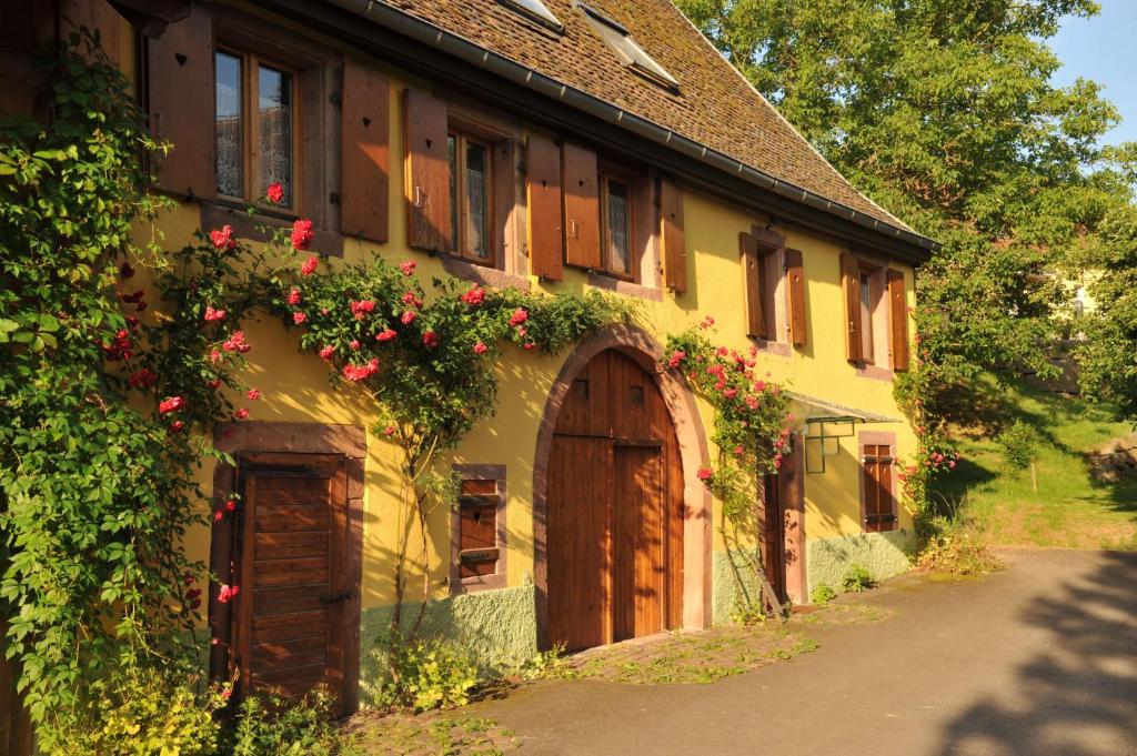 une maison avec des fleurs sur le côté dans l'établissement Couleurs Nature, à Thanvillé