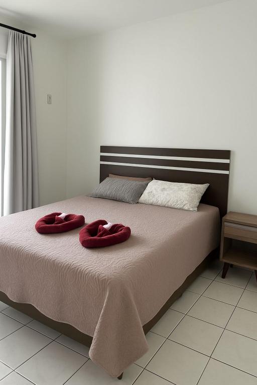 zwei rote Handtücher auf einem Bett in einem Schlafzimmer in der Unterkunft Hotel Menegatti in Pato Branco