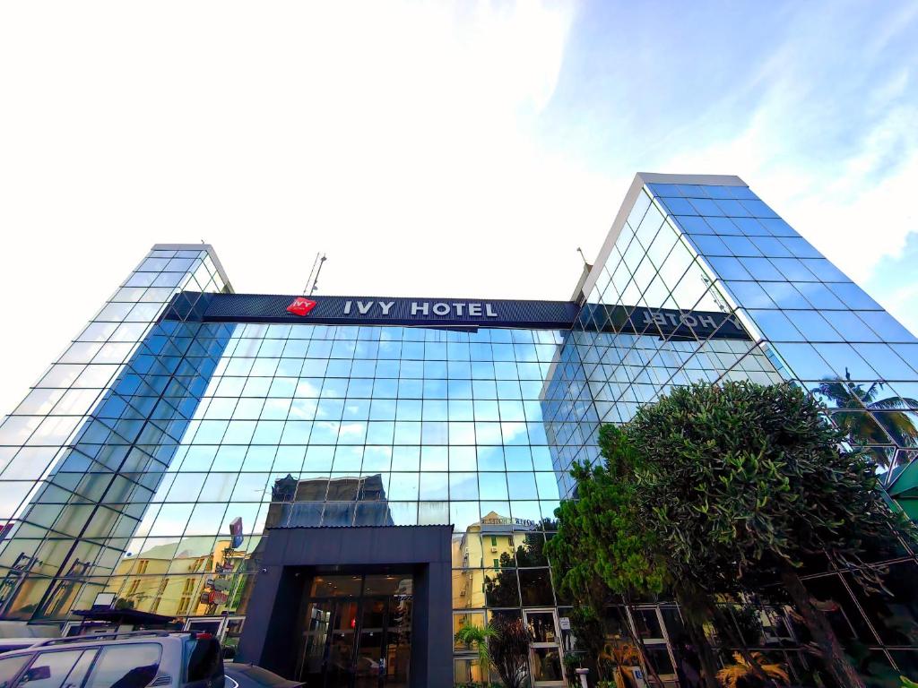 un grande edificio in vetro con un cartello sopra di Ivy Hotel Aromire a Hausa