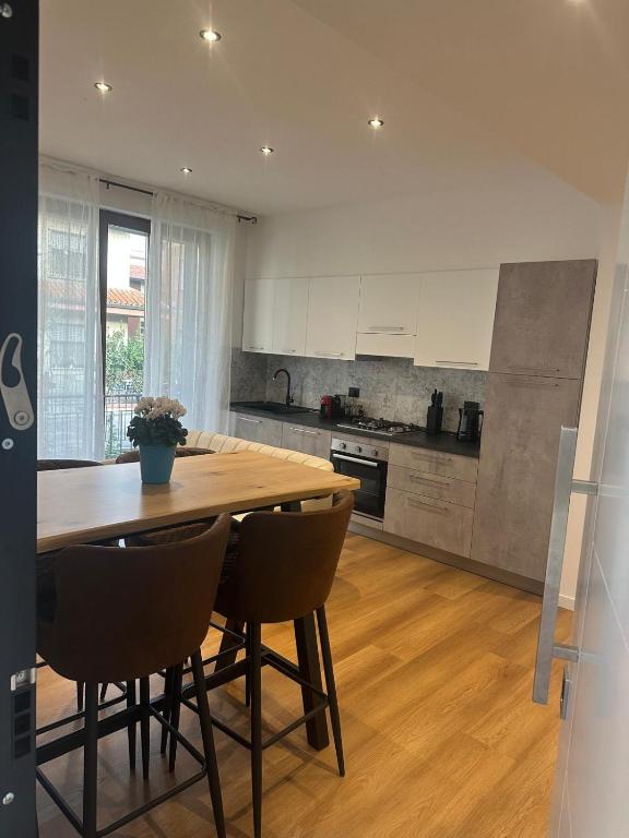 a large kitchen with a wooden table and chairs at White Swan Apartment in Peschiera del Garda