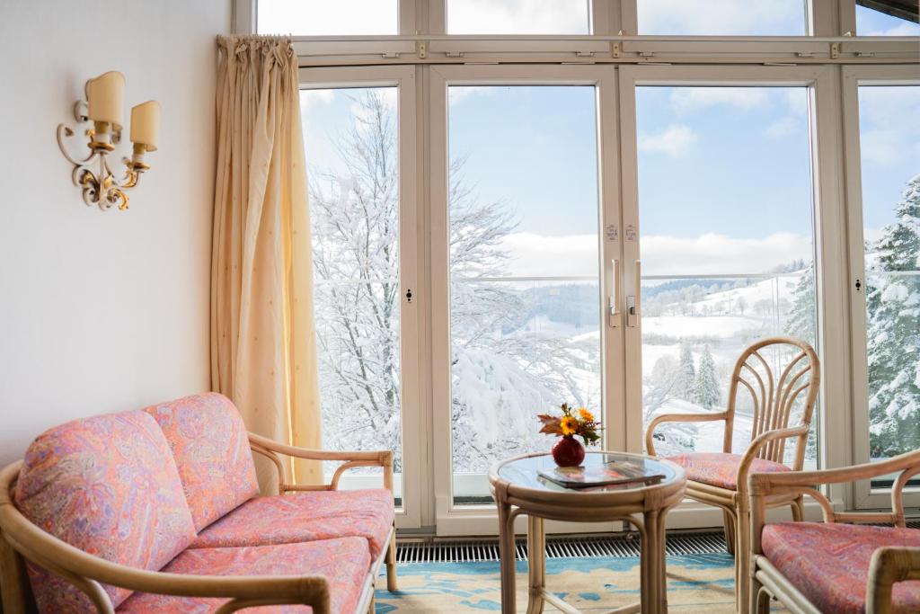 a living room with a couch and chairs and a large window at Bergvital Hotel Todtnau in Todtnau