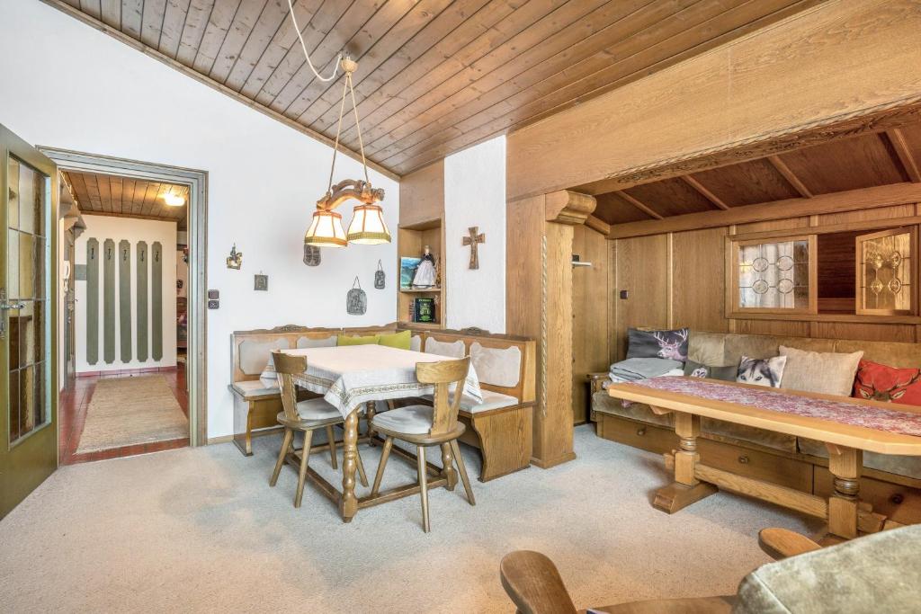 ein Esszimmer mit einem Tisch und einem Bett in der Unterkunft Maxls Stubn in Maria Alm am Steinernen Meer