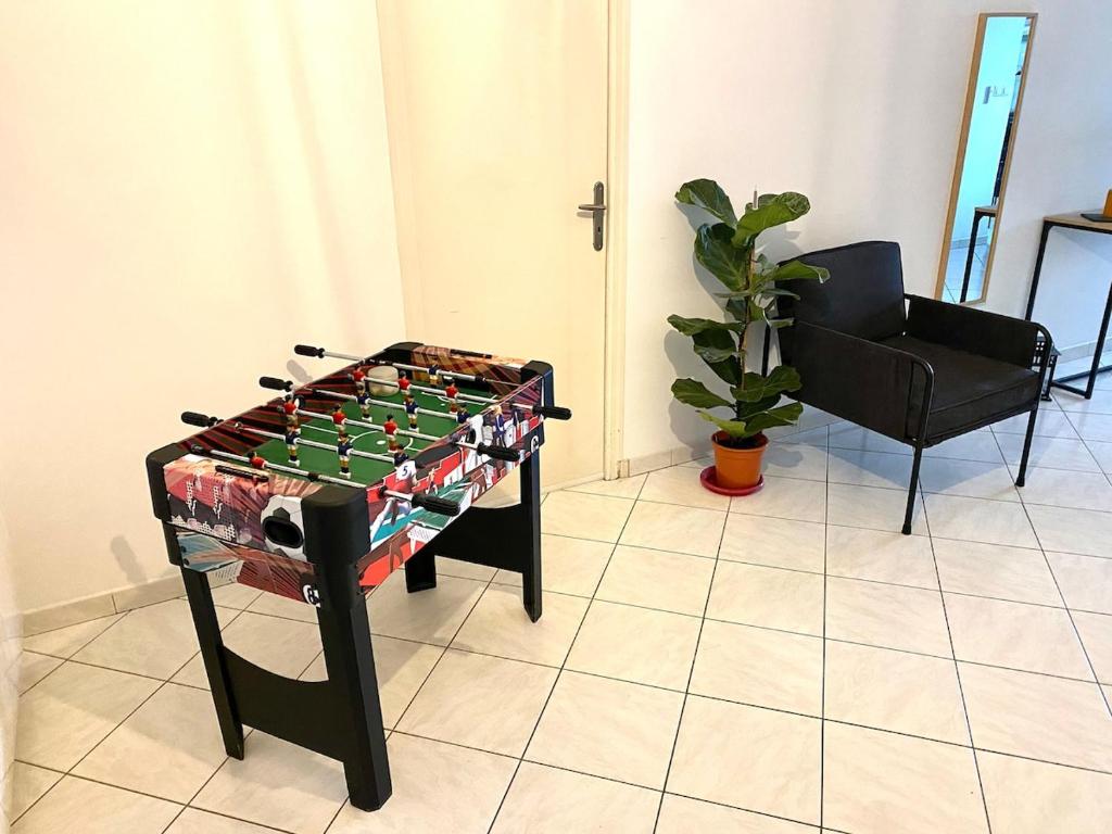 a foosball table in a room with a chair at Appartement au calme - T3, Ancenis, A11 in Mésanger