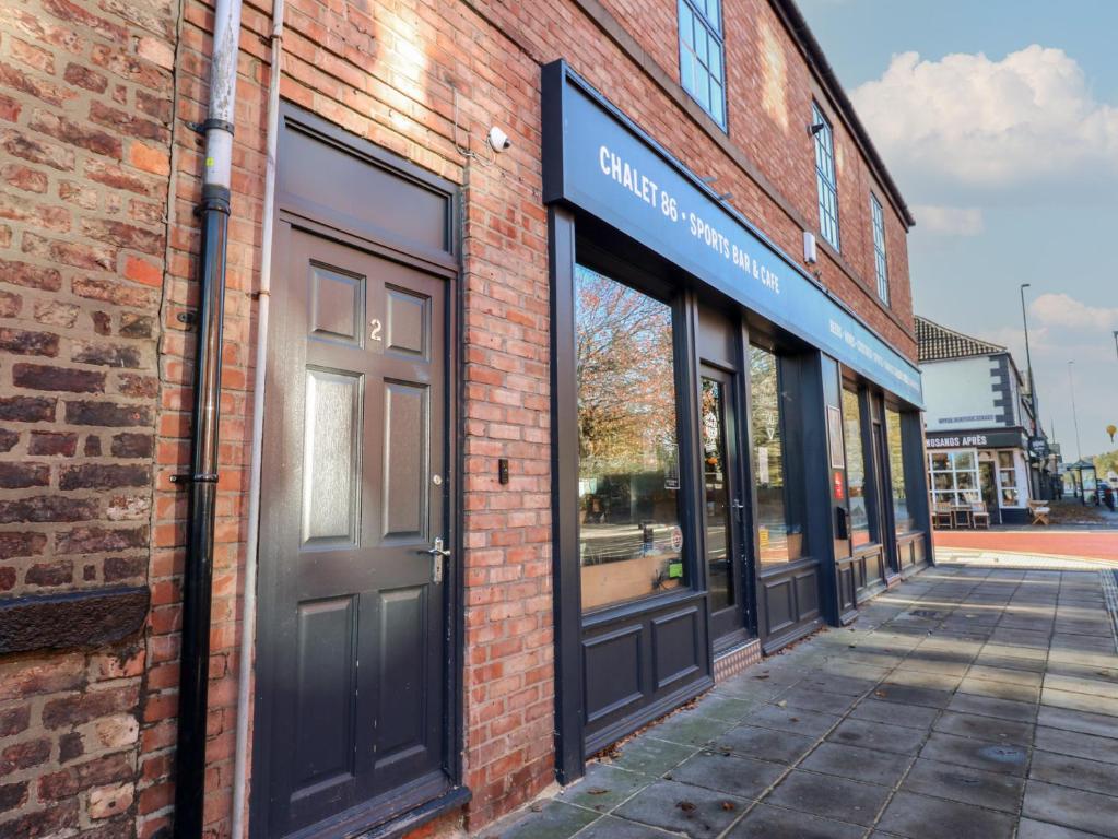 een bakstenen gebouw met deuren en ramen aan een straat bij Chalet 86 in South Shields