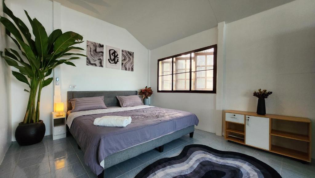 una camera da letto con un letto e una pianta in vaso di Elena Blu Beach Villa a Ko Phangan