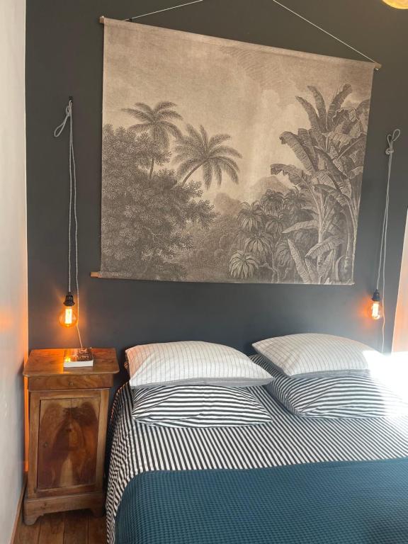 a bedroom with a bed and a painting on the wall at Maison de pêcheur proche du bourg in Ile aux Moines