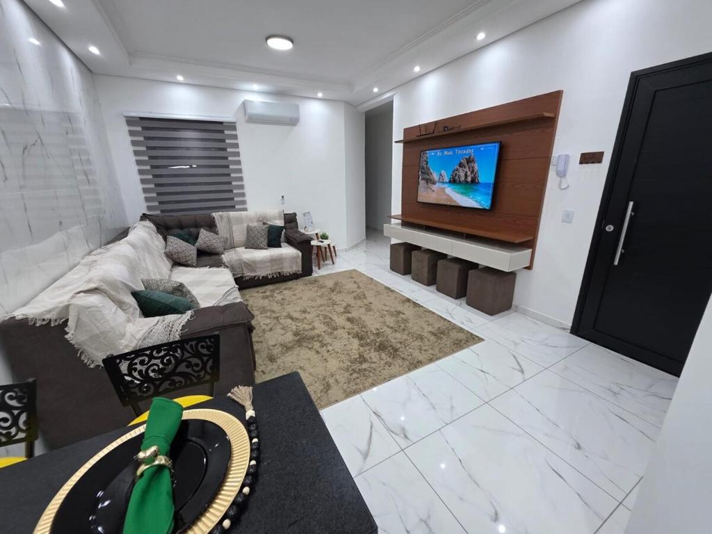 un salon avec un canapé et une télévision à écran plat dans l'établissement Apartamento Moderno Paraquesdismo e Balão, à Boituva