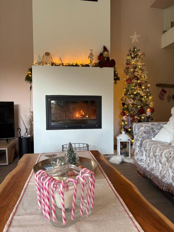 a living room with a christmas tree and a fireplace at Stellas guesthouse near Arachova in Stírion