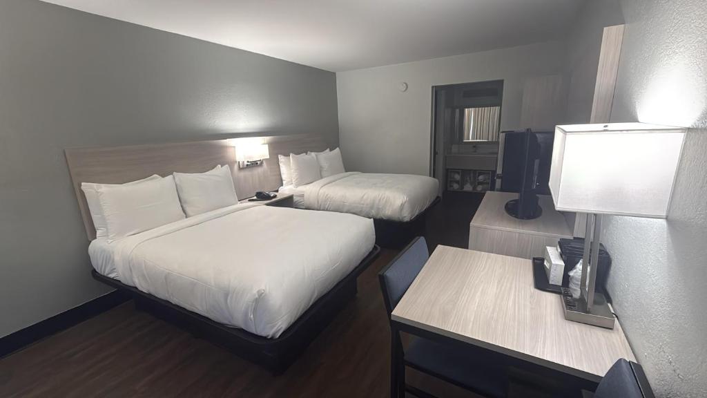 a hotel room with two beds and a desk at Econo Lodge Daytona Beach - Speedway in Daytona Beach