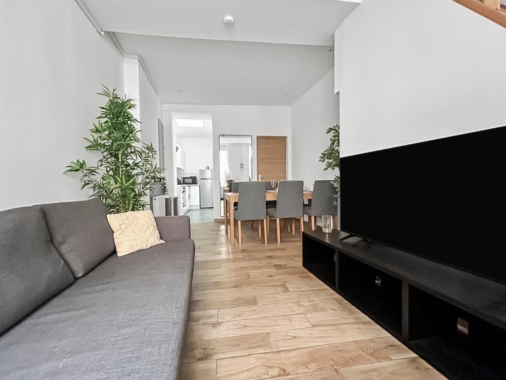 a living room with a couch and a flat screen tv at La maison peinte par Eugene Delacroix - Netflix in Cambrai