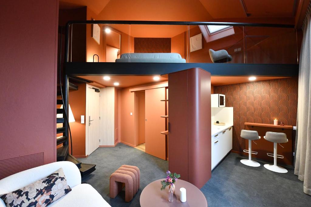 a small apartment with a bunk bed and a kitchen at Hôtel La SUITE & restaurant Le DÔME in Roanne