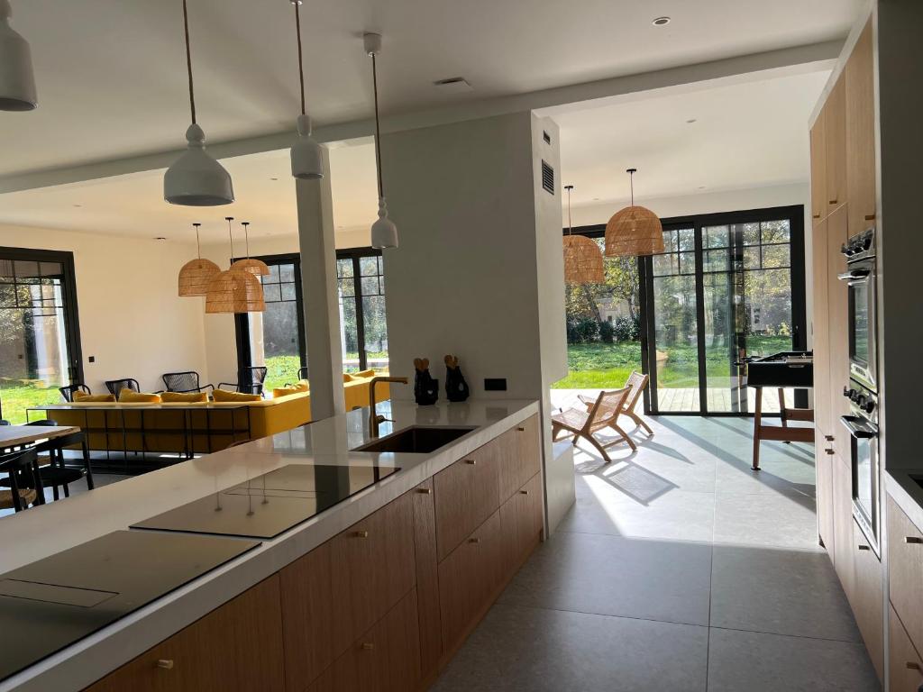 an open kitchen and dining room with a dining table at Villa Lombardière in Gujan-Mestras