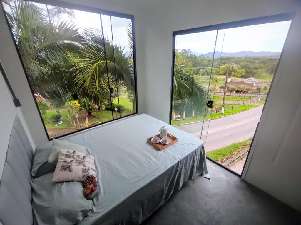 Un dormitorio con una cama y una ventana grande. en Morada do Altíssimo, en Florianópolis
