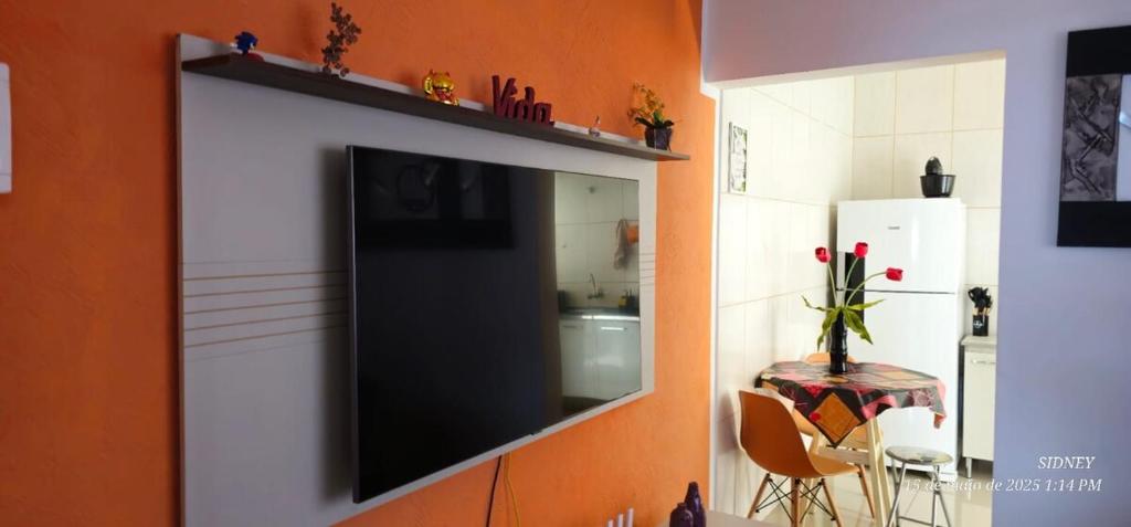 a flat screen tv on a wall in a kitchen at Apartamento Centro à 100 metros da Praça da Matriz in Boituva