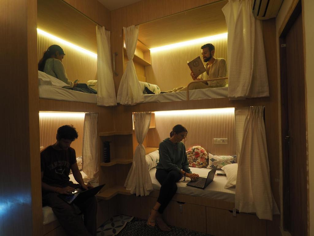 斋浦尔Joey's Hostel的一群人坐在一个房间里,手提电脑