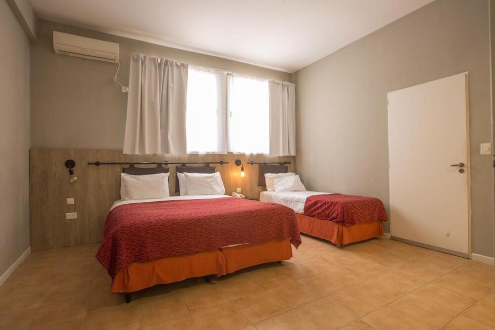 a bedroom with two beds and a window at Vilaró Art Wine Hotel in Buenos Aires