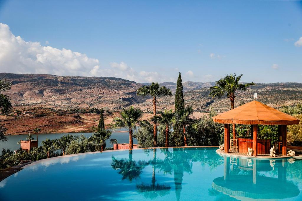 una grande piscina con gazebo accanto a un lago di Widiane Resort a Bine el Ouidane