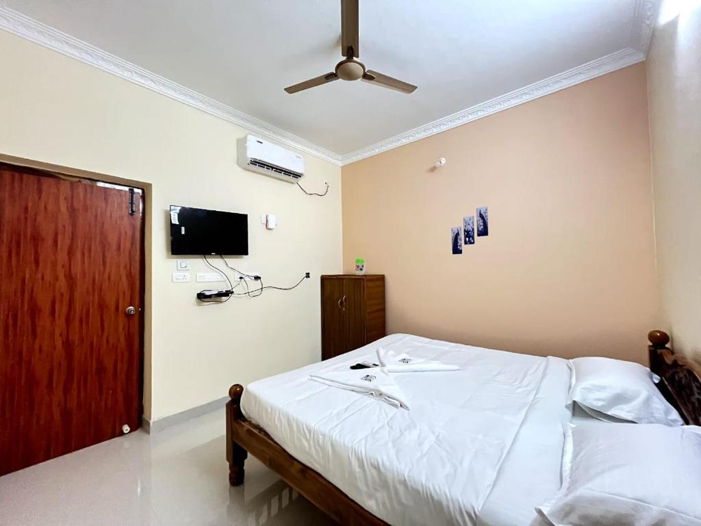 a bedroom with a bed and a ceiling fan at Dream Promenade Residency in Puducherry