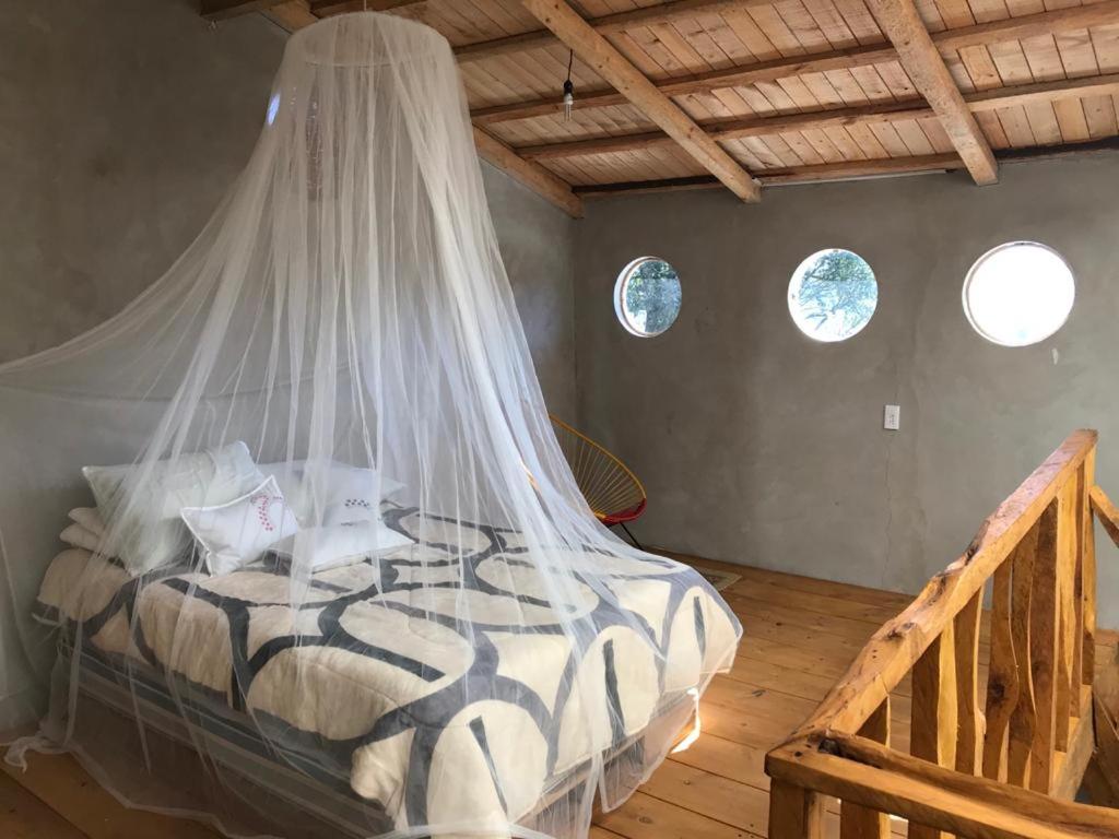 a bedroom with a bed with a mosquito net at Cabaña de descanso en Tlazala in Cedro