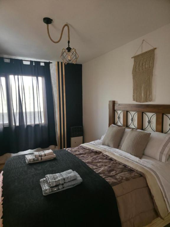 里奥格兰德Temporario RG的一间卧室，有一张大床，床上有两条毛巾