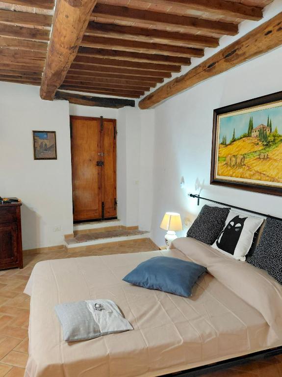 a bedroom with a large bed with a wooden ceiling at La Dimora di Dida in Seggiano