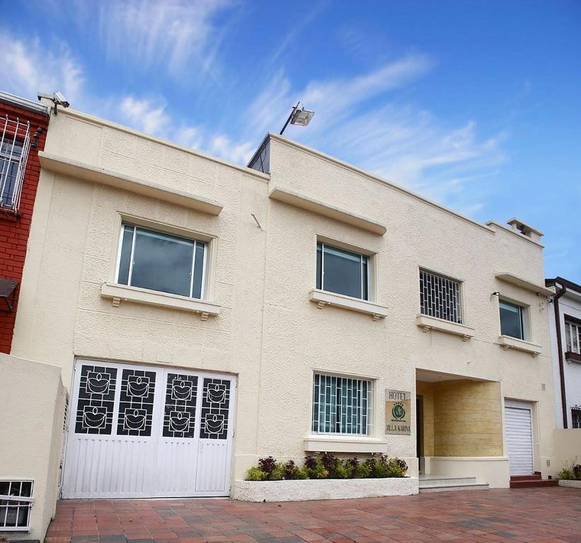 a large white house with a white garage at Hotel Villa Karina in Bogotá
