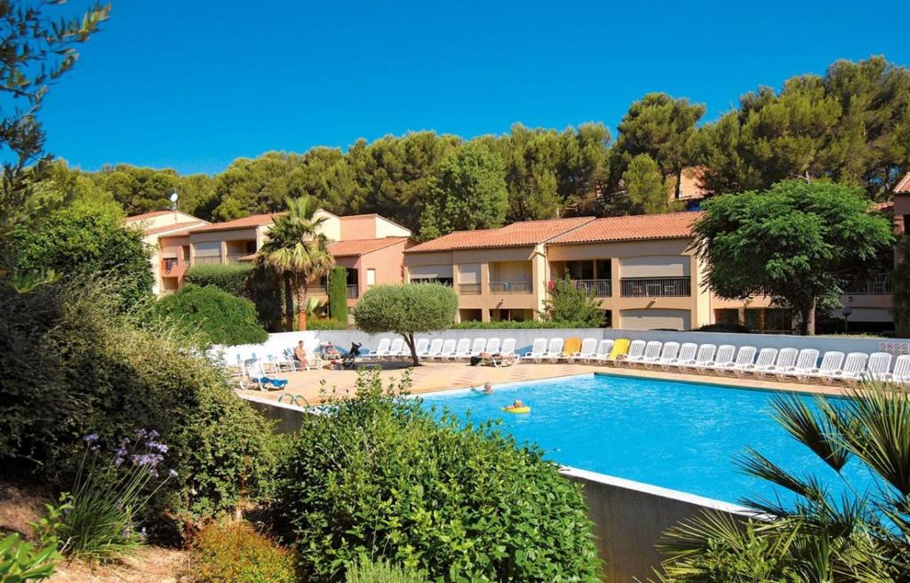 ein Swimmingpool vor einem Ferienresort in der Unterkunft Le Nid du Vallon -studio- Plage & Piscine in Sanary-sur-Mer