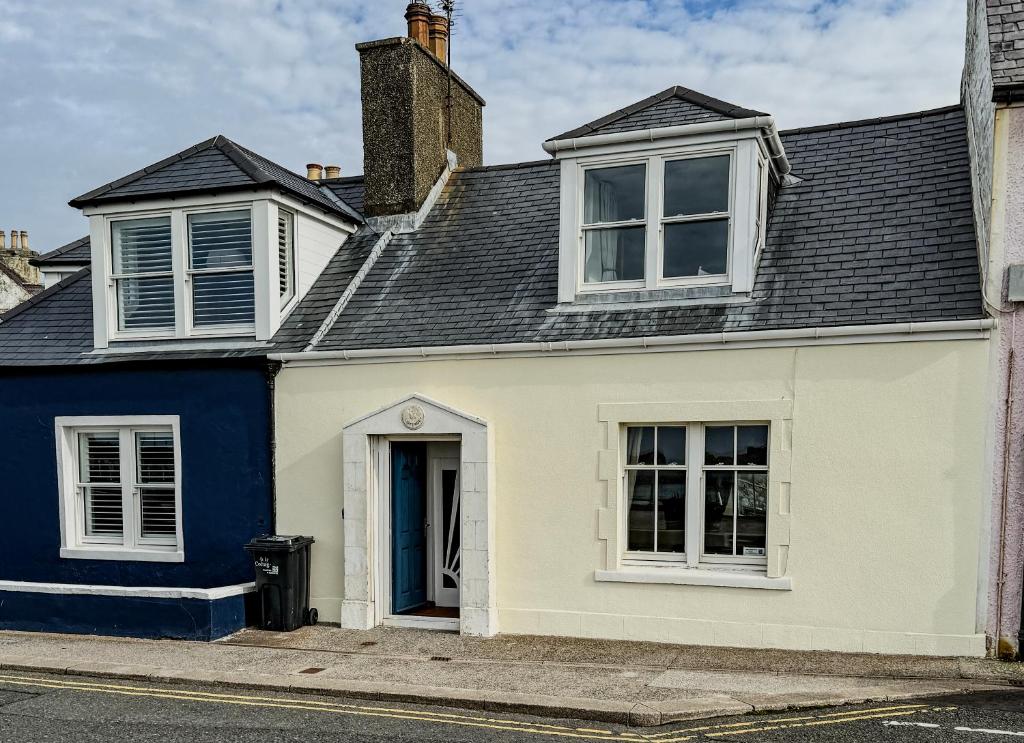 een wit en blauw huis met een zwart dak bij Moir Cottage in Portpatrick