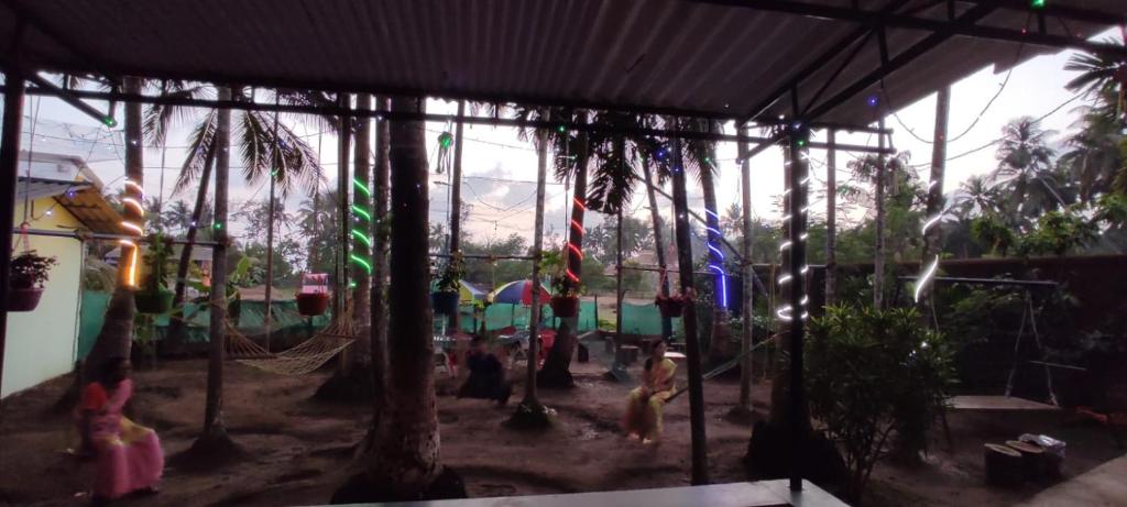 um parque infantil com balanços e crianças brincando nele em Shraddha Cottage em Nagaon