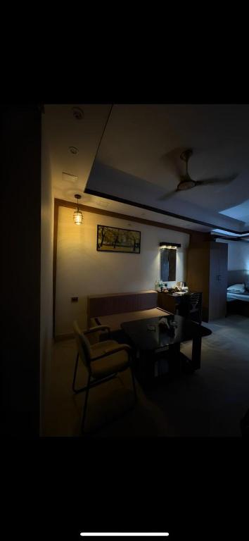 a living room with a table and a chair at Ostro Inn Royal Studio Apartment Shakespeare Sarani in Kolkata