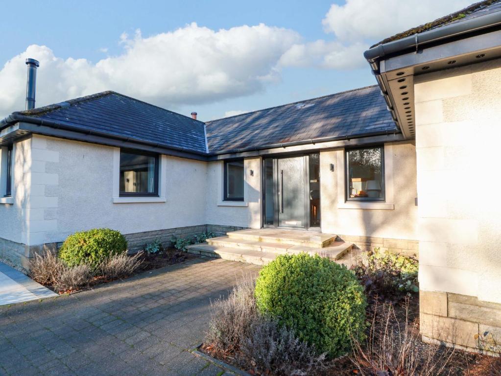 a white house with a slate roof at Cramar Cottage in Glasgow