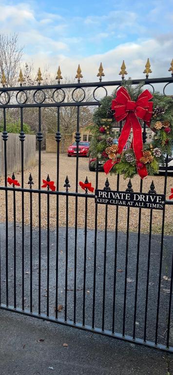 a christmas tree on a black fence with a red bow at Highcroft House in Corsham