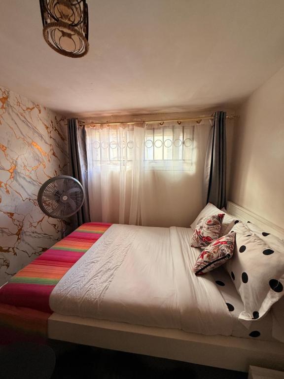 Un dormitorio pequeño con una cama con ventana. en The Hideout-Studio Apartment in Westlands, en Nairobi