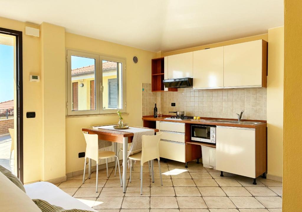 een keuken met een tafel en stoelen in een kamer bij Holihome Vascello B21 in Tortoreto Lido