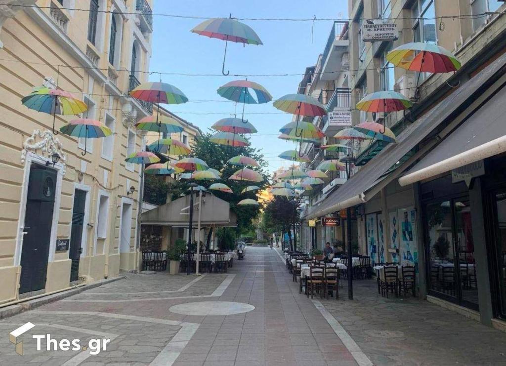 eine Straße, an deren Gebäuden viele Regenschirme hängen. in der Unterkunft Sroom in Kardítsa