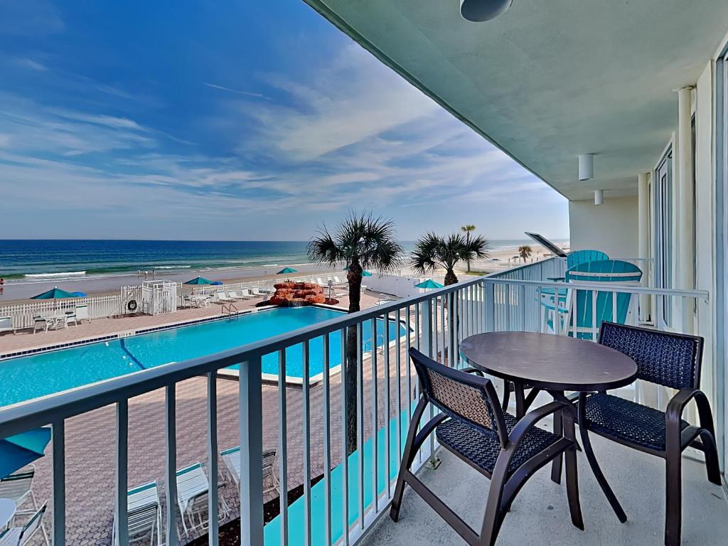 a balcony with a table and chairs and the beach at Harbour Beach Resort 203 in Seabreeze