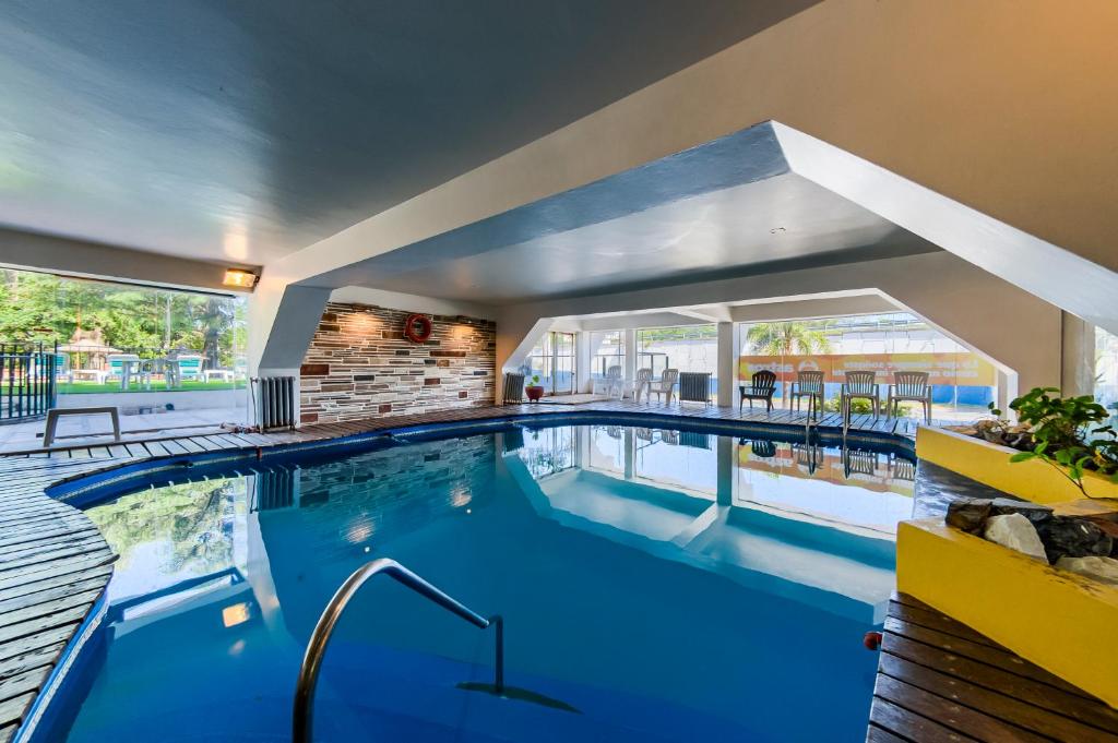 a large pool with blue water in a building at Gran Hotel Las Lajas in Villa Carlos Paz