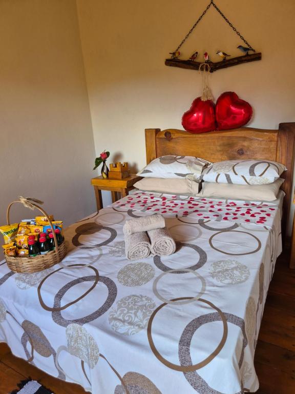 a bed with towels and a basket on it at Cabana refúgio do tico tico 07 in Cunha