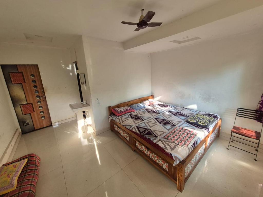 een slaapkamer met een bed en een plafondventilator bij anandi holidays homestay in Malvan