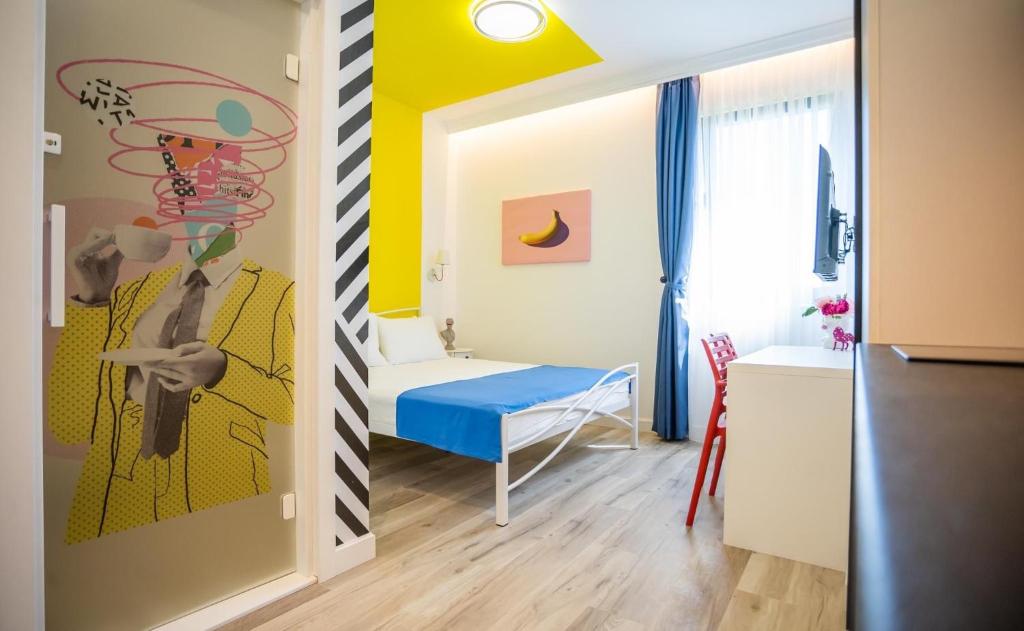 Una pequeña habitación con una cama y un dormitorio con amarillo. en Studio Pop Art, en Batajnica