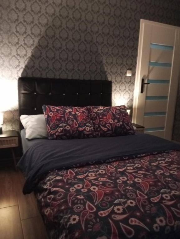 a bedroom with a bed with a red comforter at Apartament Chopina 17 in Włocławek