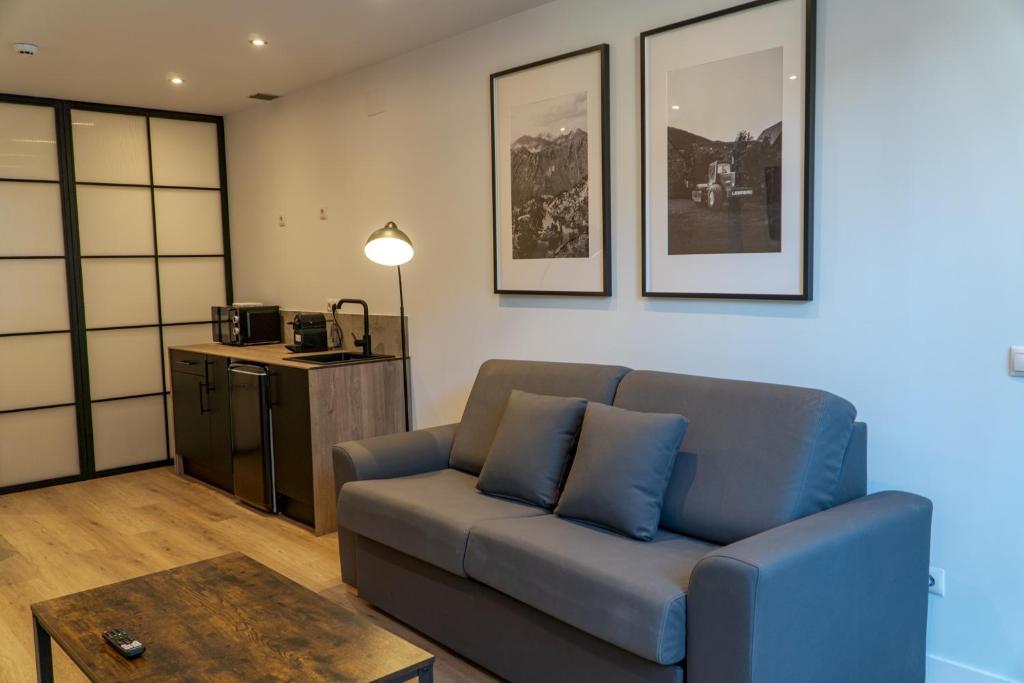 a living room with a blue couch and a table at La Borda del Gato Rafa in Vielha