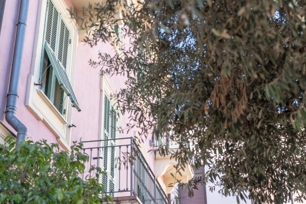 un edificio rosa con un balcone e una finestra di LC Boutique Hotel ad Arma di Taggia
