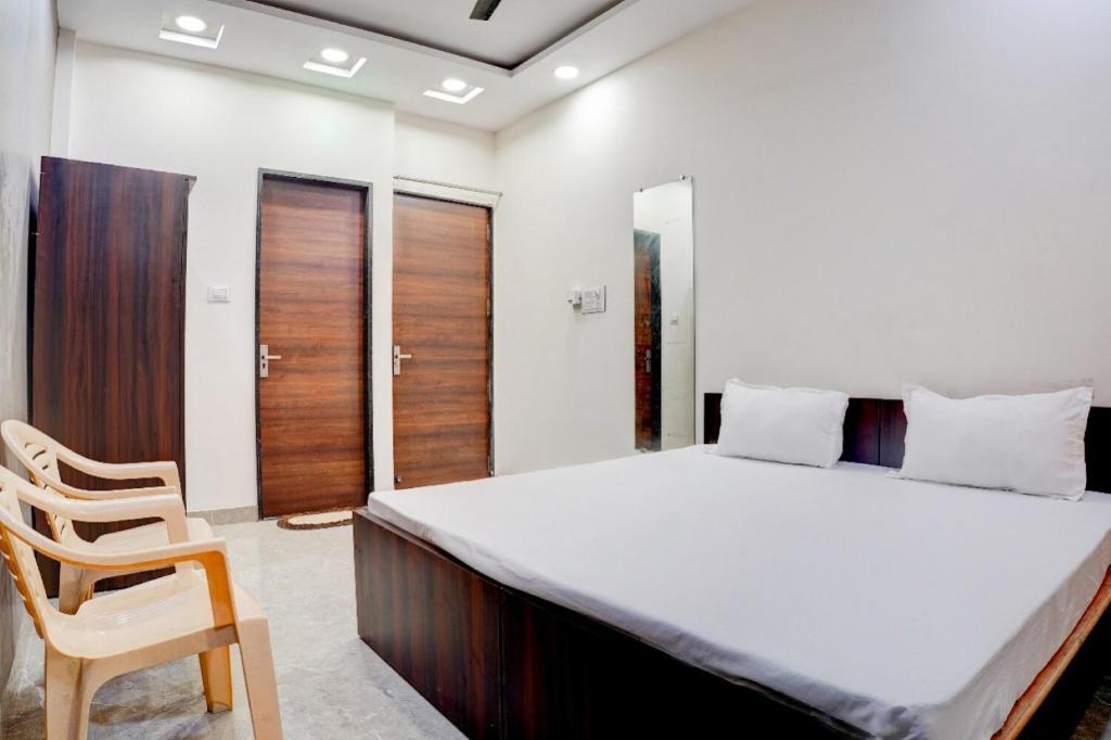 a bedroom with a large bed and a chair at Hotel O The Kavish in Somarda Kauasot